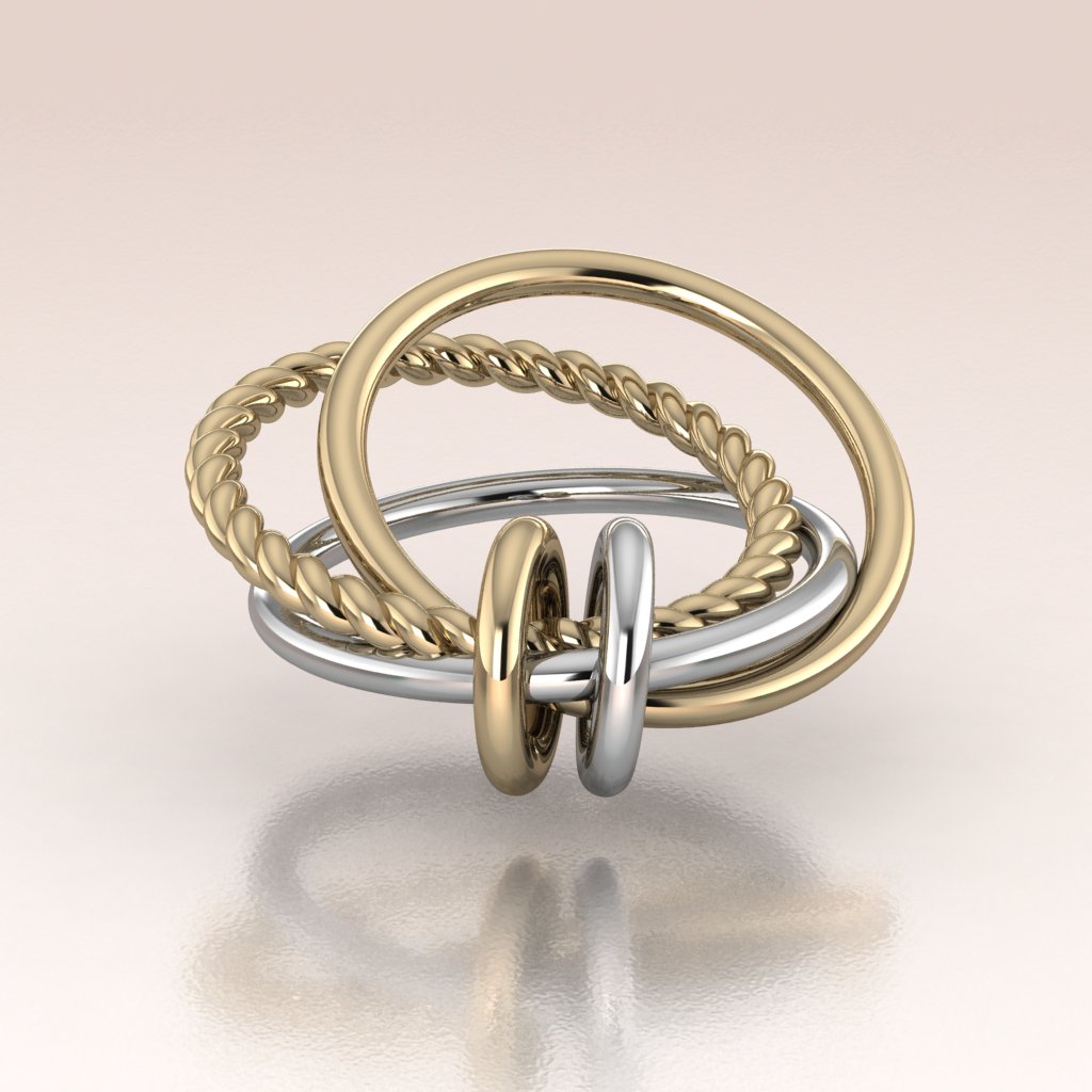 Three gold rings in two tone yellow and white gold stacked on a reflective surface with a light background