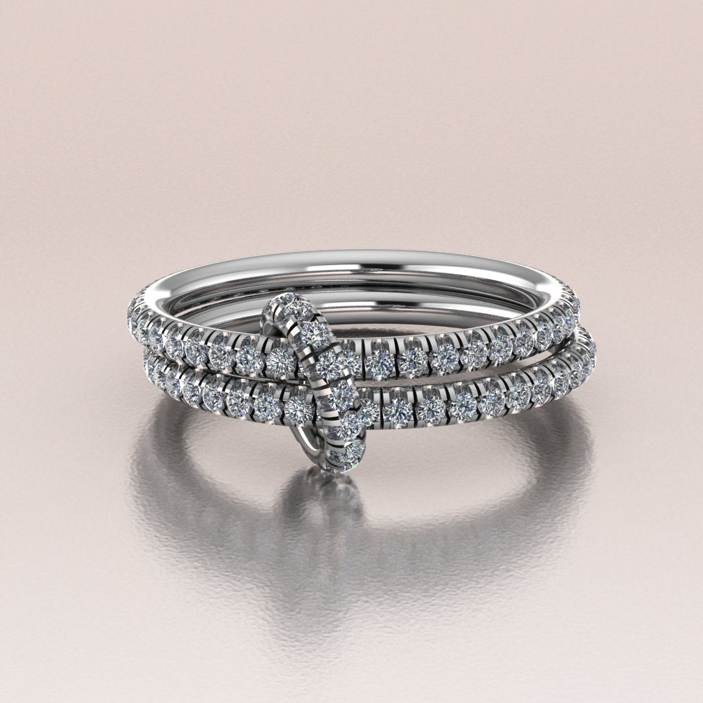 Stack of white gold diamond rings on a beige background