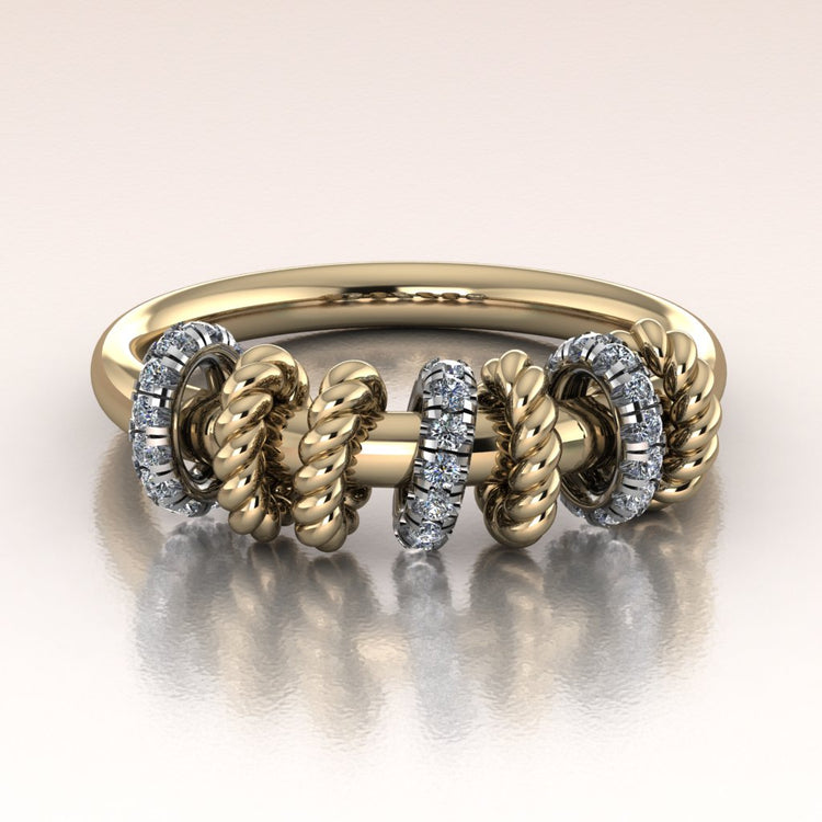 Gold ring with intricate twist rope design and moving diamond links on a light background