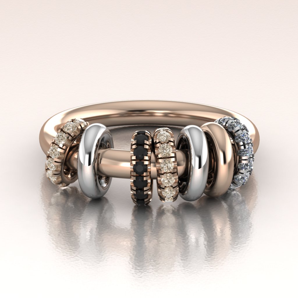 Stack of rose gold and white gold rings with diamond accents on a reflective surface