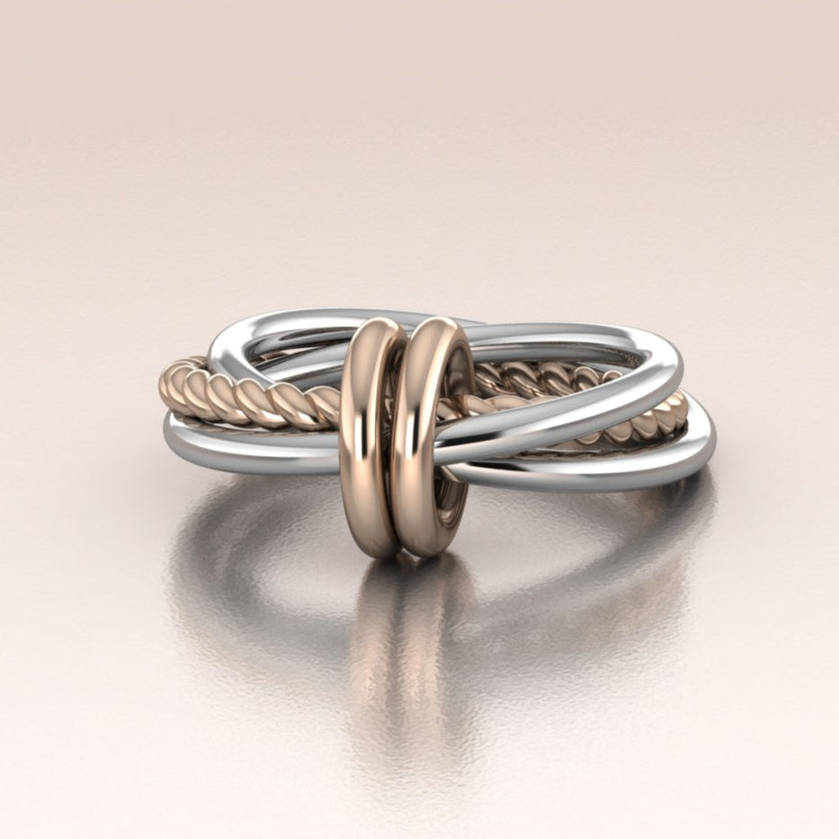 Two-toned ring with interlocking design on a beige background