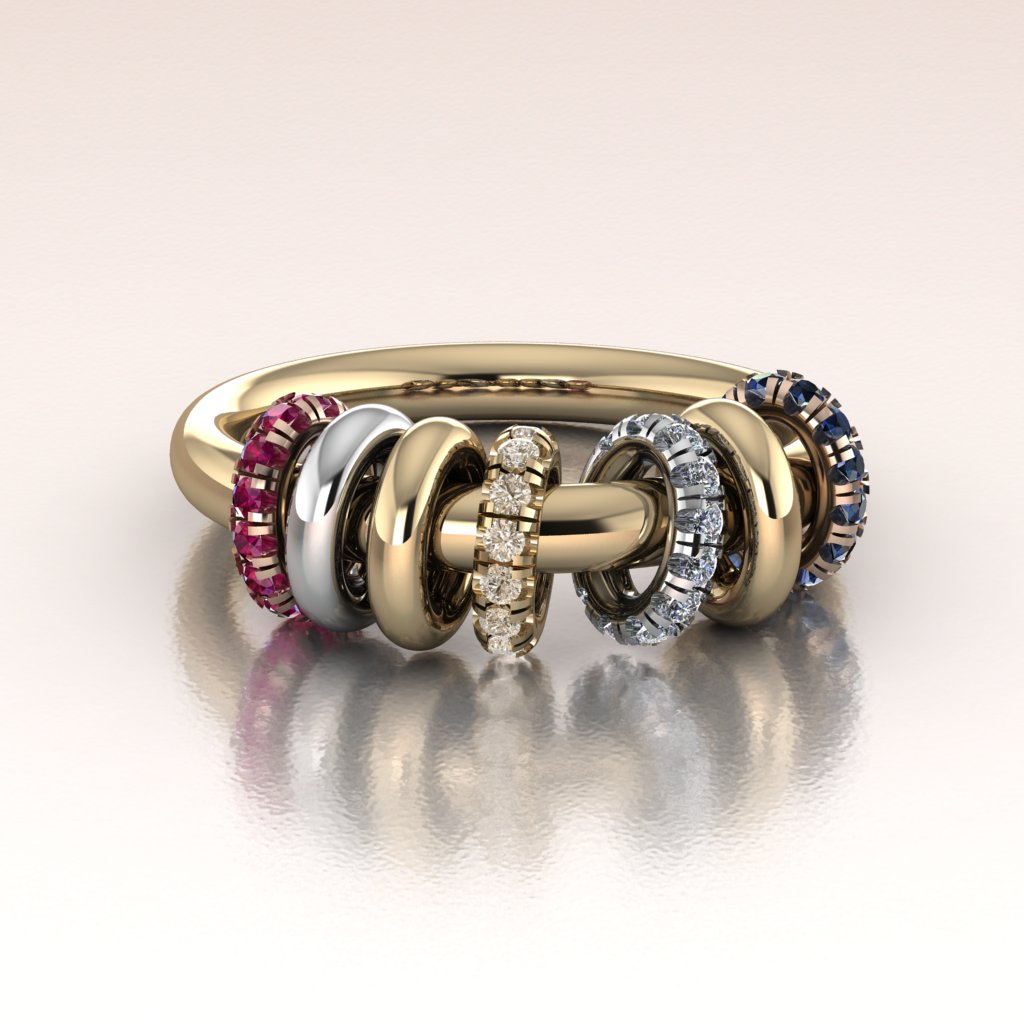 Gold ring with multicolored gemstones on a reflective surface