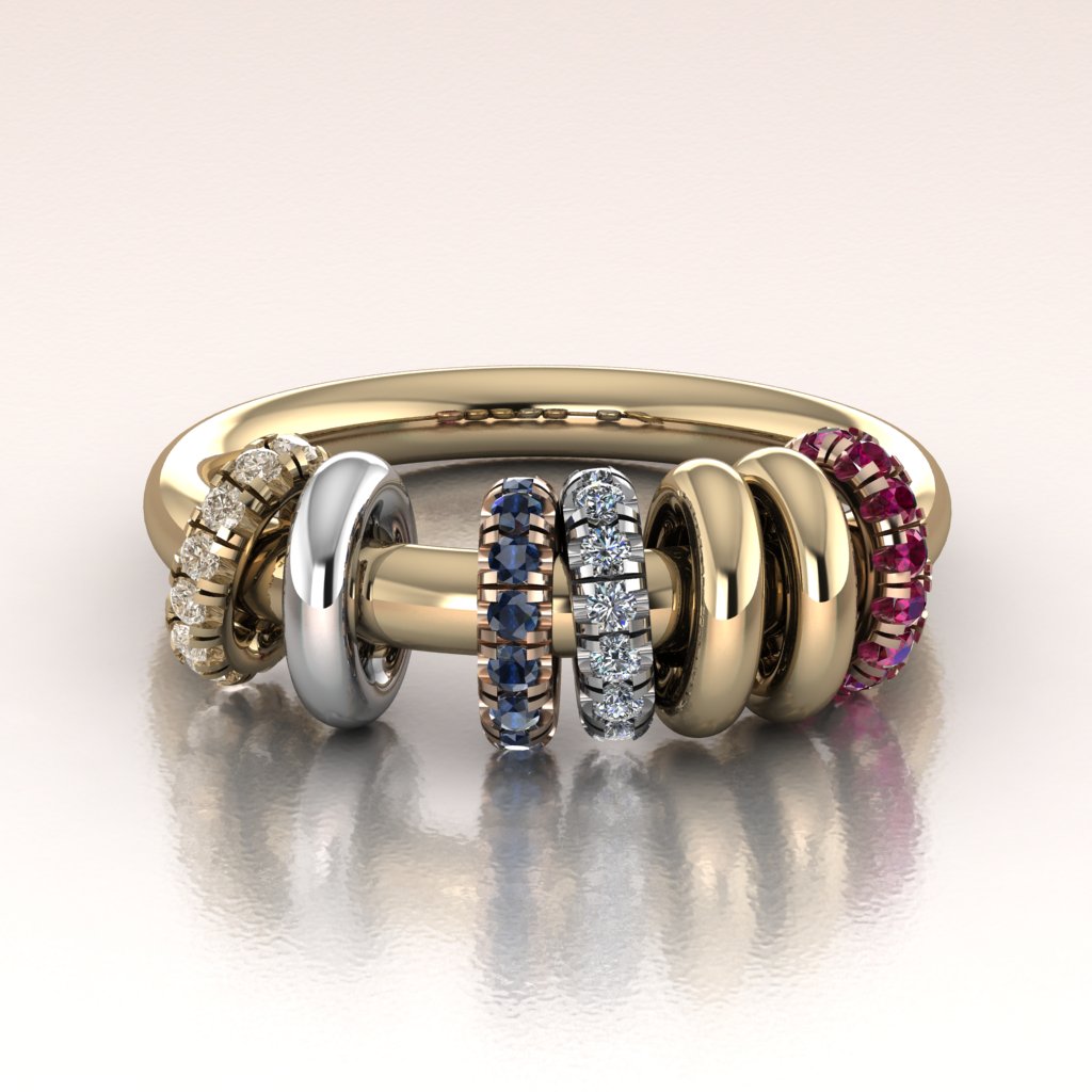 Gold ring with various gemstone-studded bands on a white background